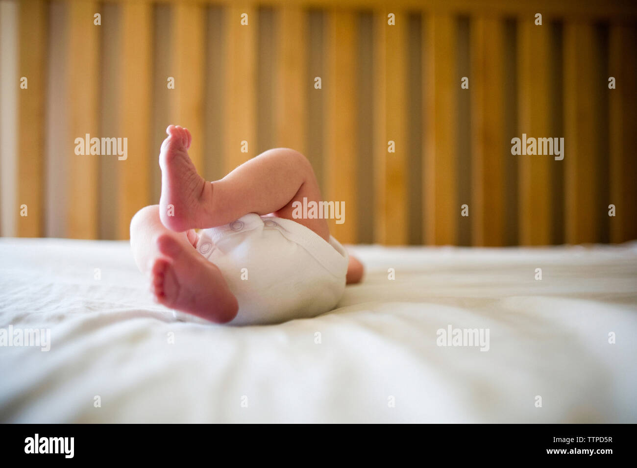 Low section of newborn baby girl lying in crib at home Stock Photo Alamy