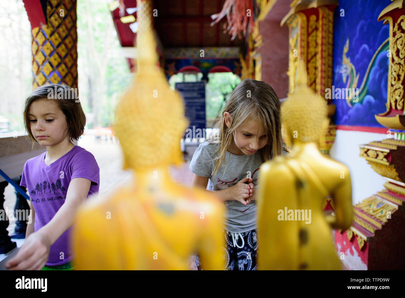 Girls praying at Buddhist temple Stock Photo