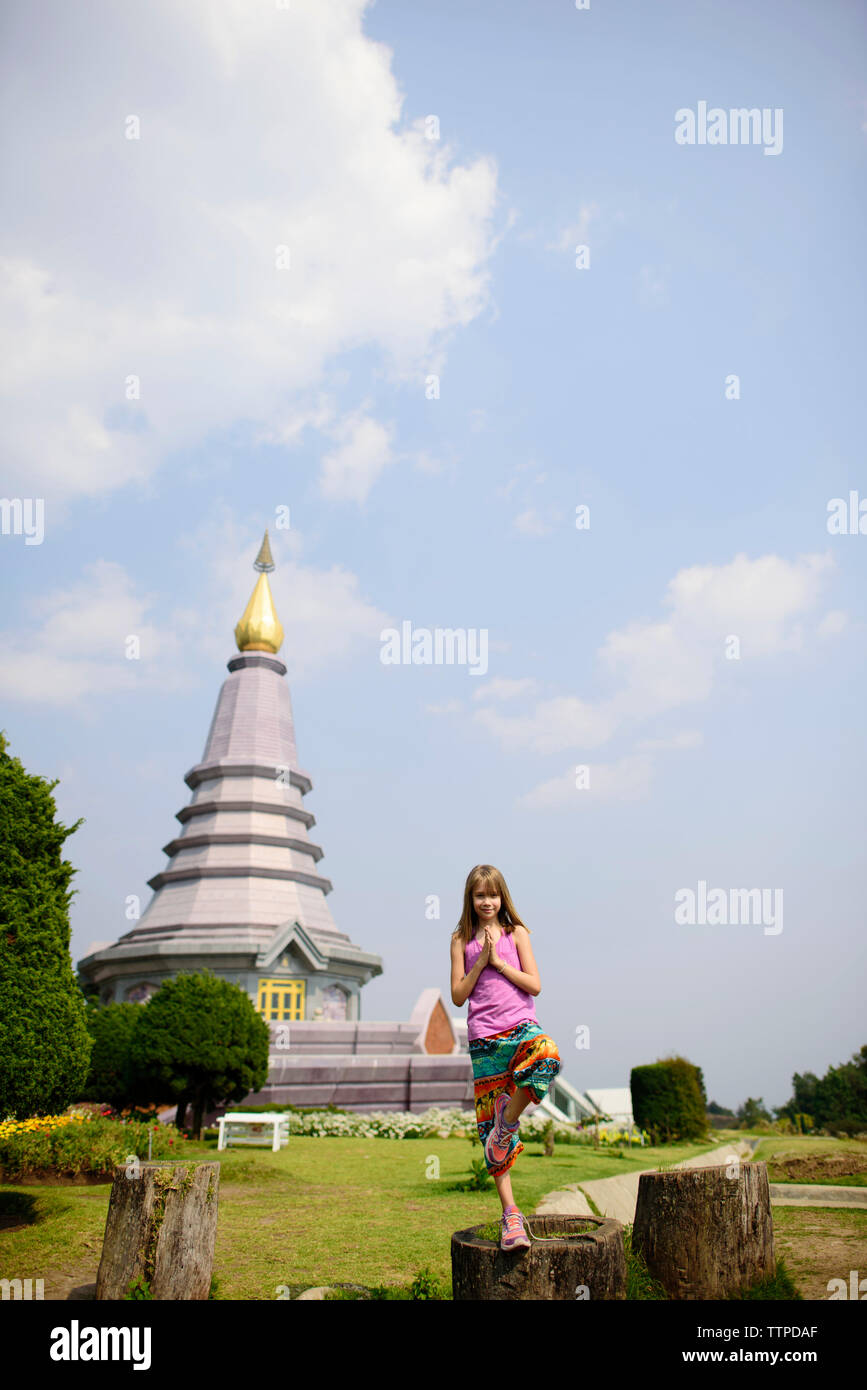 Girl standing in tree pose against pagoda at Doi Inthanon National Park Stock Photo