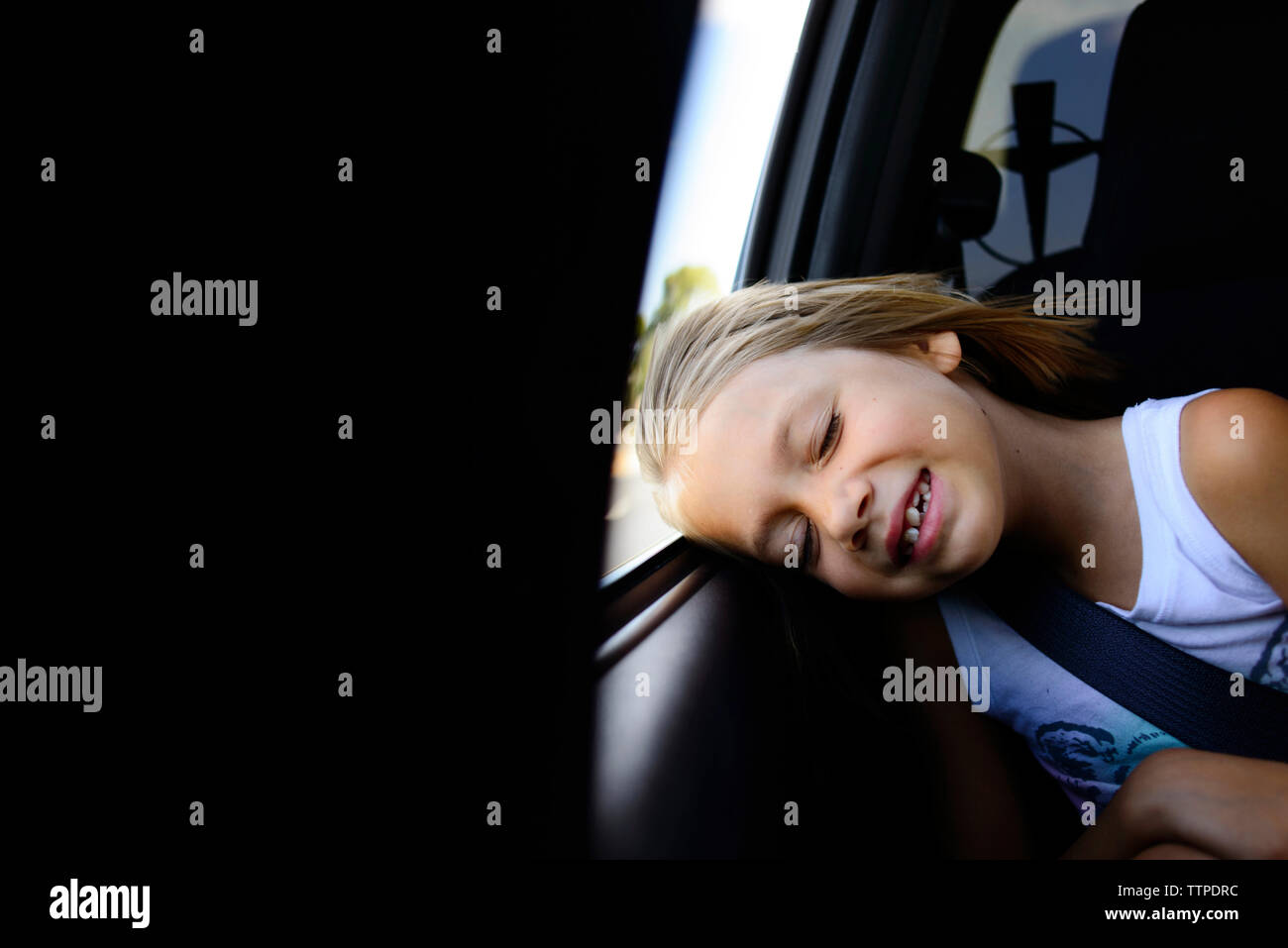 Girl napping while sitting in car Stock Photo