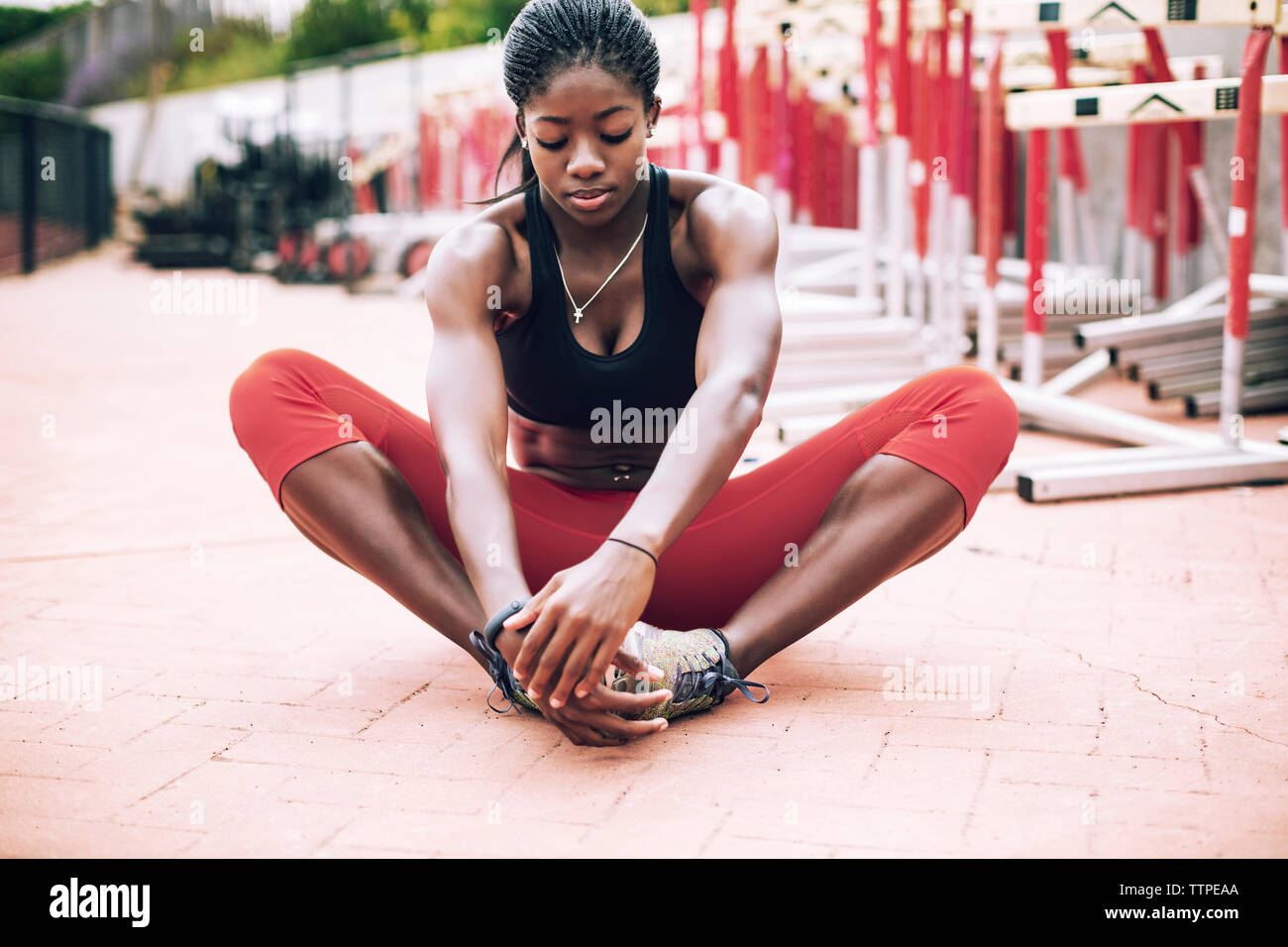 Female athlete performing short adductor stretch on field Stock Photo
