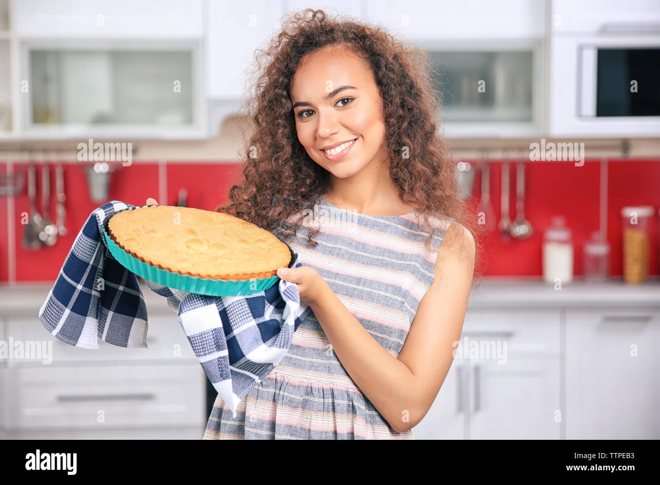 Beautiful African girl with cake in kitchen Stock Photo - Alamy