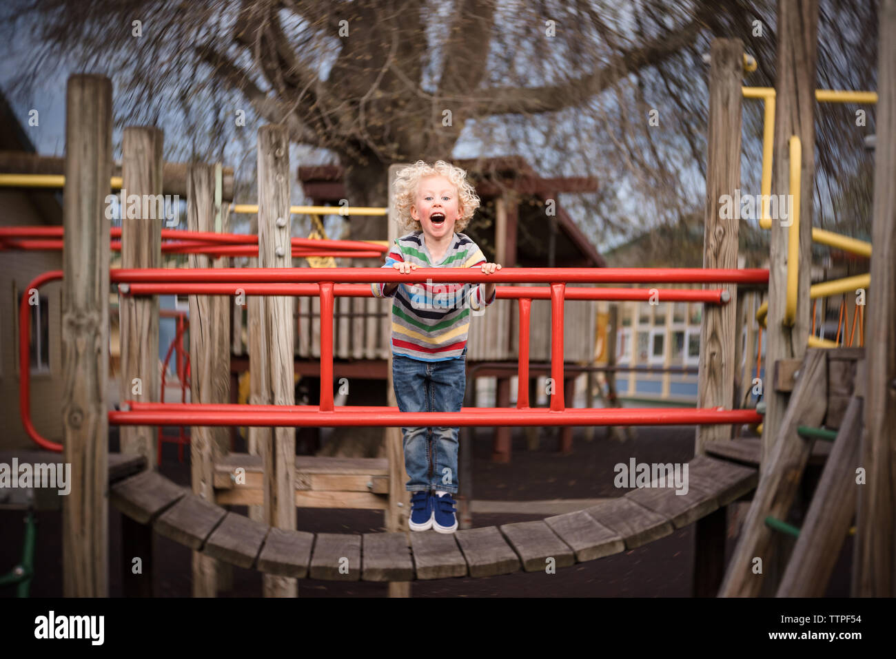 Young boy laughing and playing on playground at a park Stock Photo