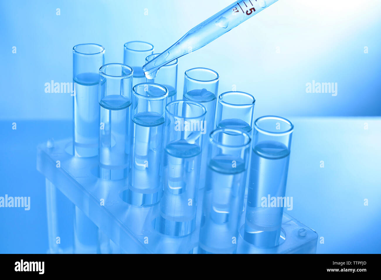 Close up of a pipette dropping sample into a test tube Stock Photo - Alamy