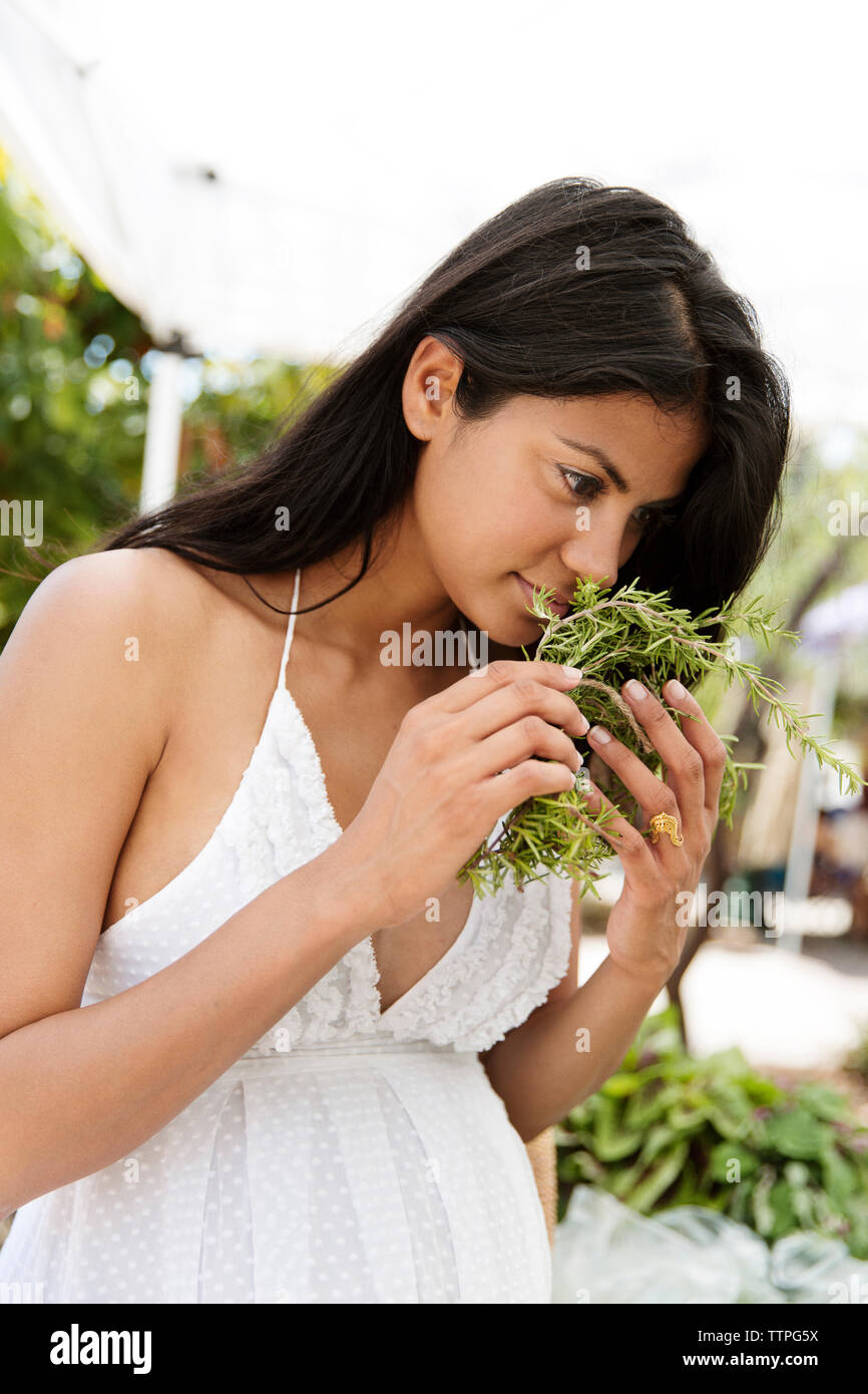 Woman smelling fresh herbs at market Stock Photo