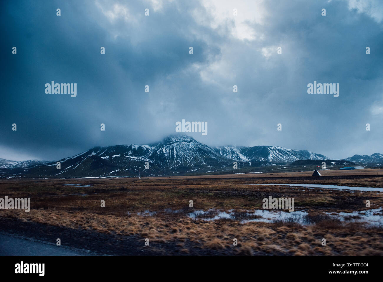 Snow capped Mountains over field in Iceland Stock Photo