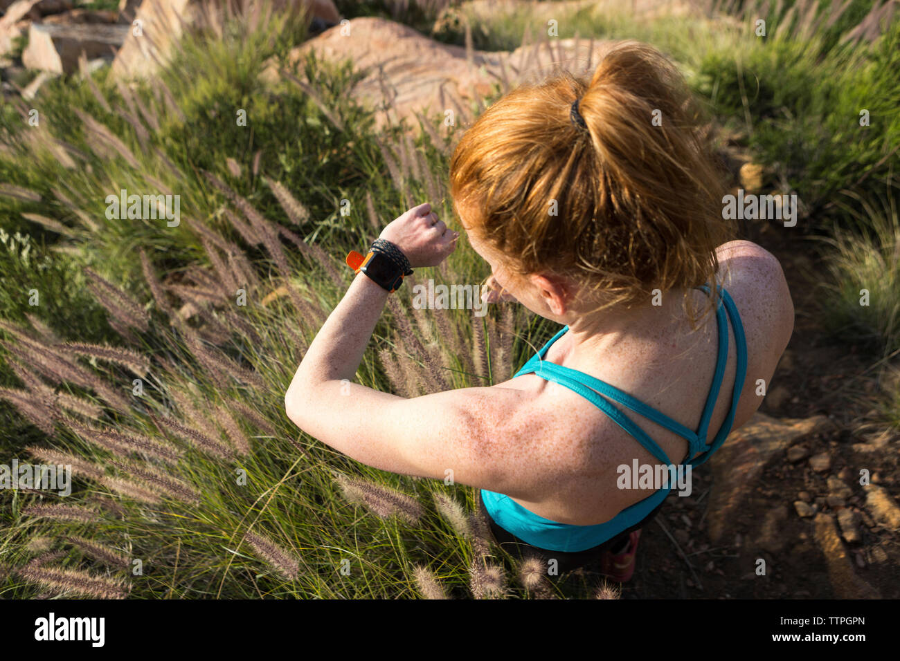 High angle view of woman checking time while standing on field Stock Photo