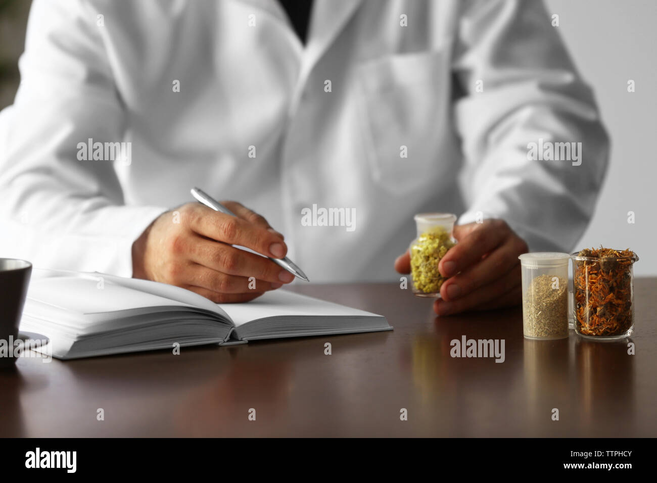 Male doctor with medical recipe book. Herbal medicine concept Stock Photo