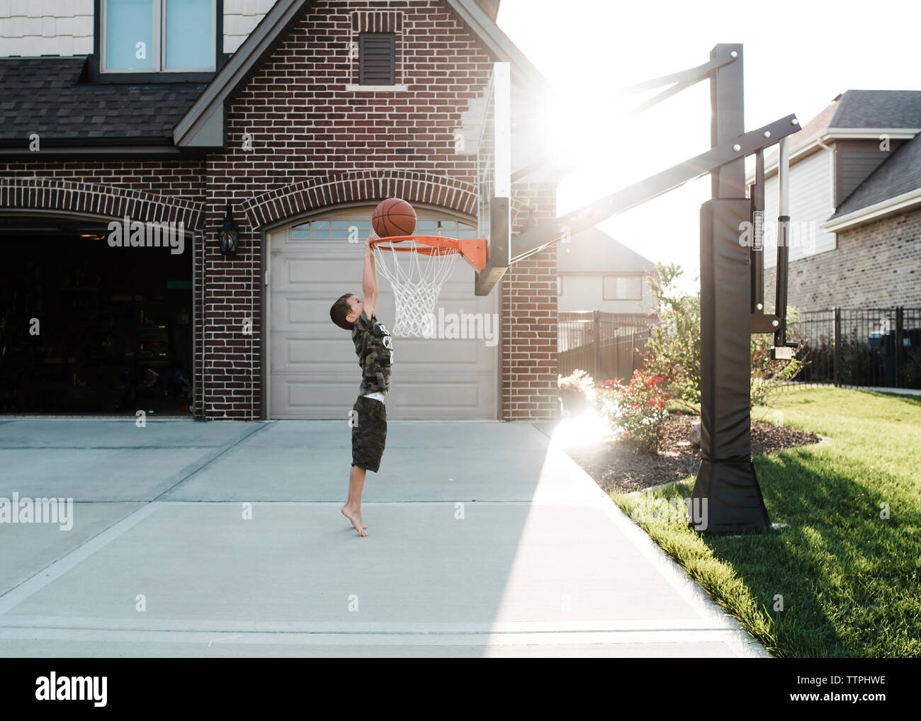 Side view of boy playing basketball in yard Stock Photo Alamy