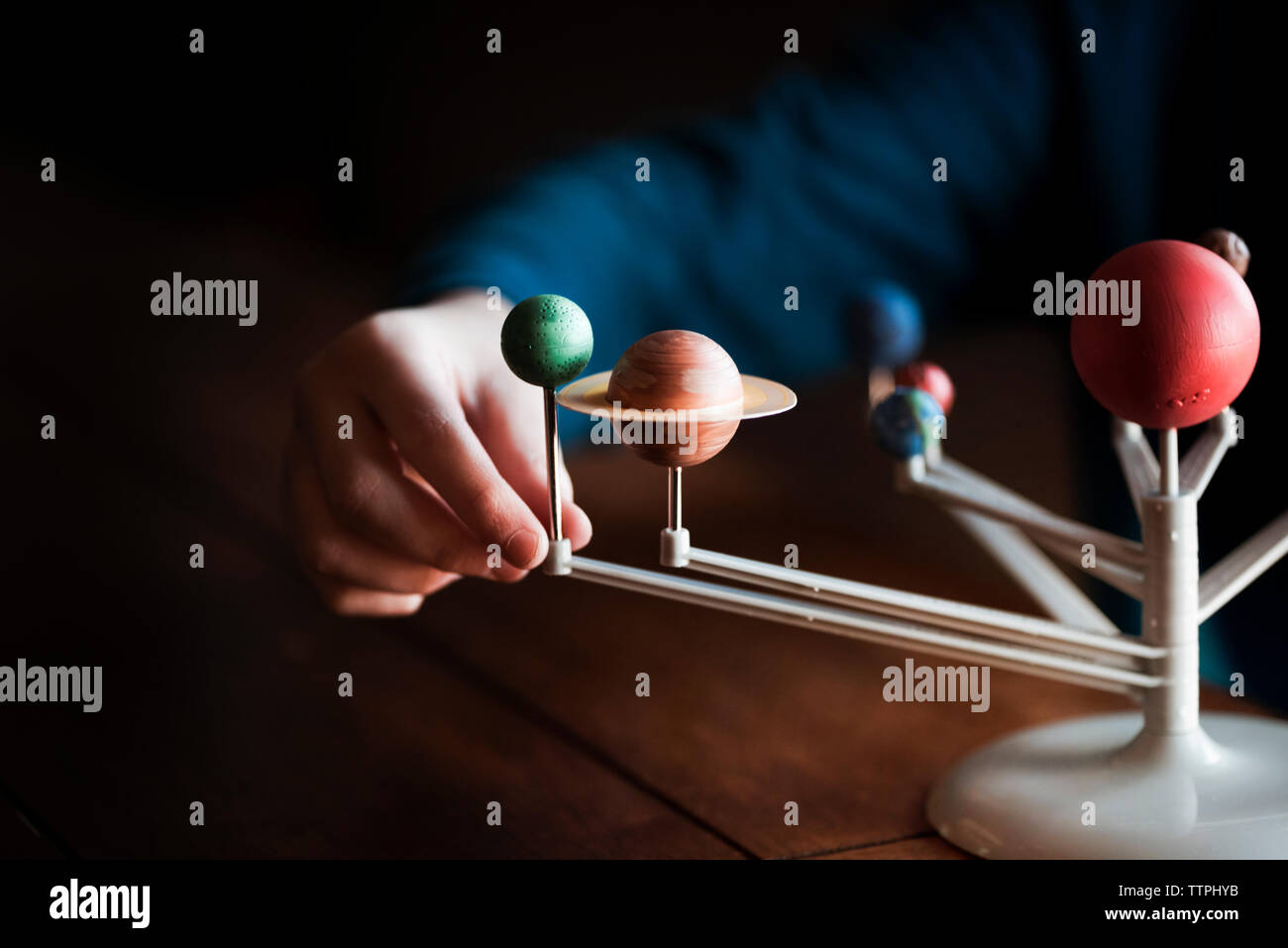 A Small Boys Hand Touching A Model Of The Solar System Stock Photo