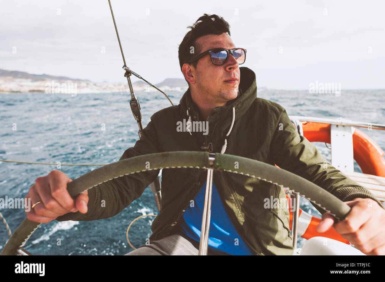 Young man driving boat on sea Stock Photo - Alamy