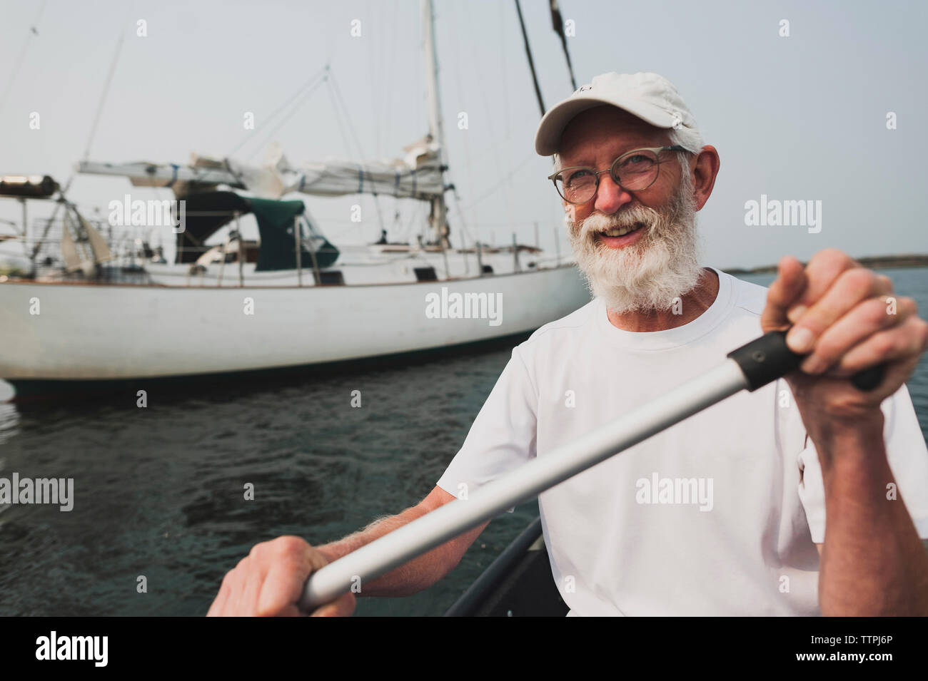 Portrait of senior man rowing boat on sea against sky Stock Photo