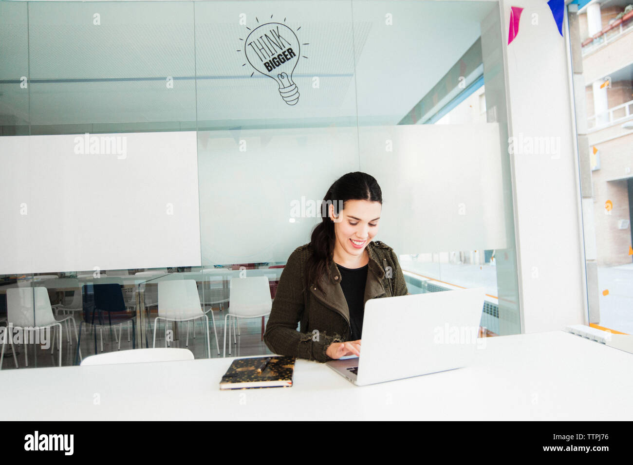 Smiling Young Hispanic Woman Working on Laptop Stock Photo
