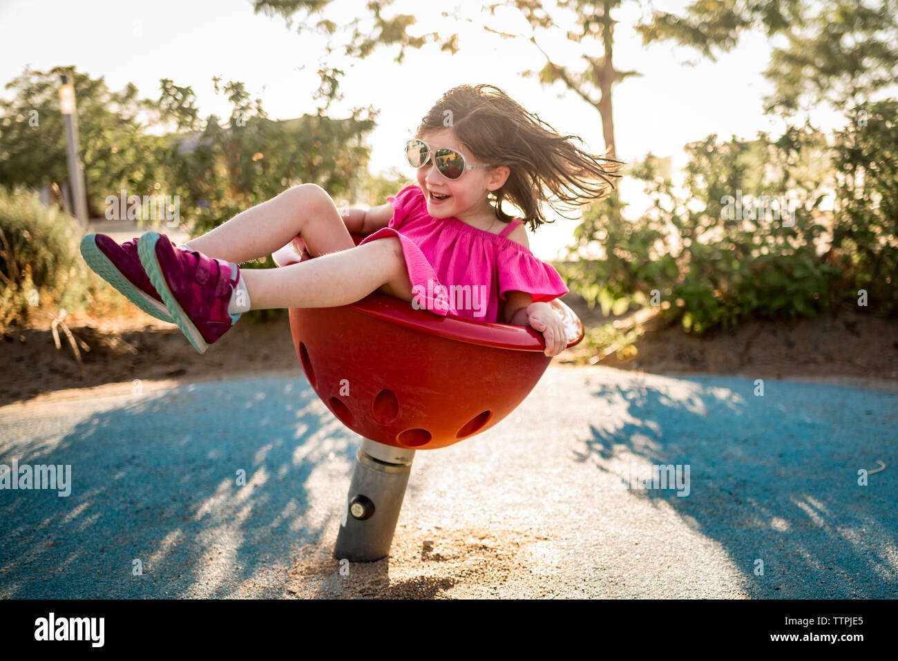 Happy girl playing on spring ride at playground Stock Photo