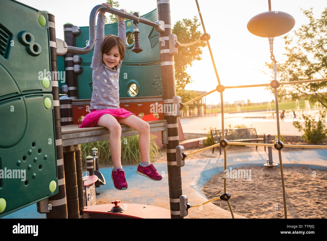Happy girl playing on outdoor play equipment at playground Stock Photo