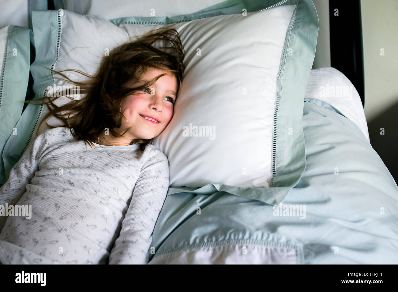 Girl lying on bed smiling hi-res stock photography and images - Alamy