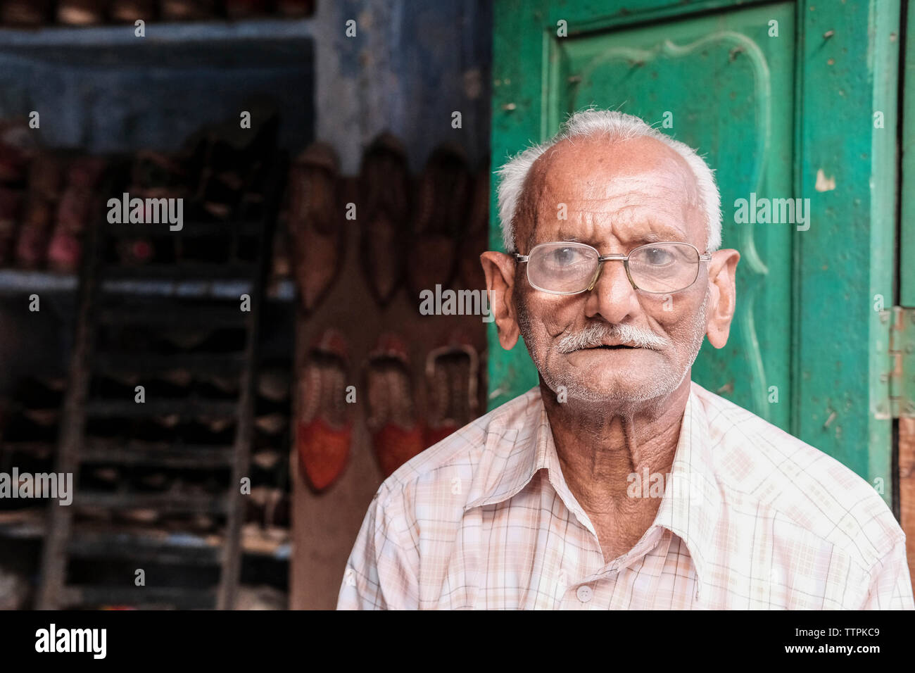 Portrait of senior shoemaker wearing eyeglasses against store Stock Photo