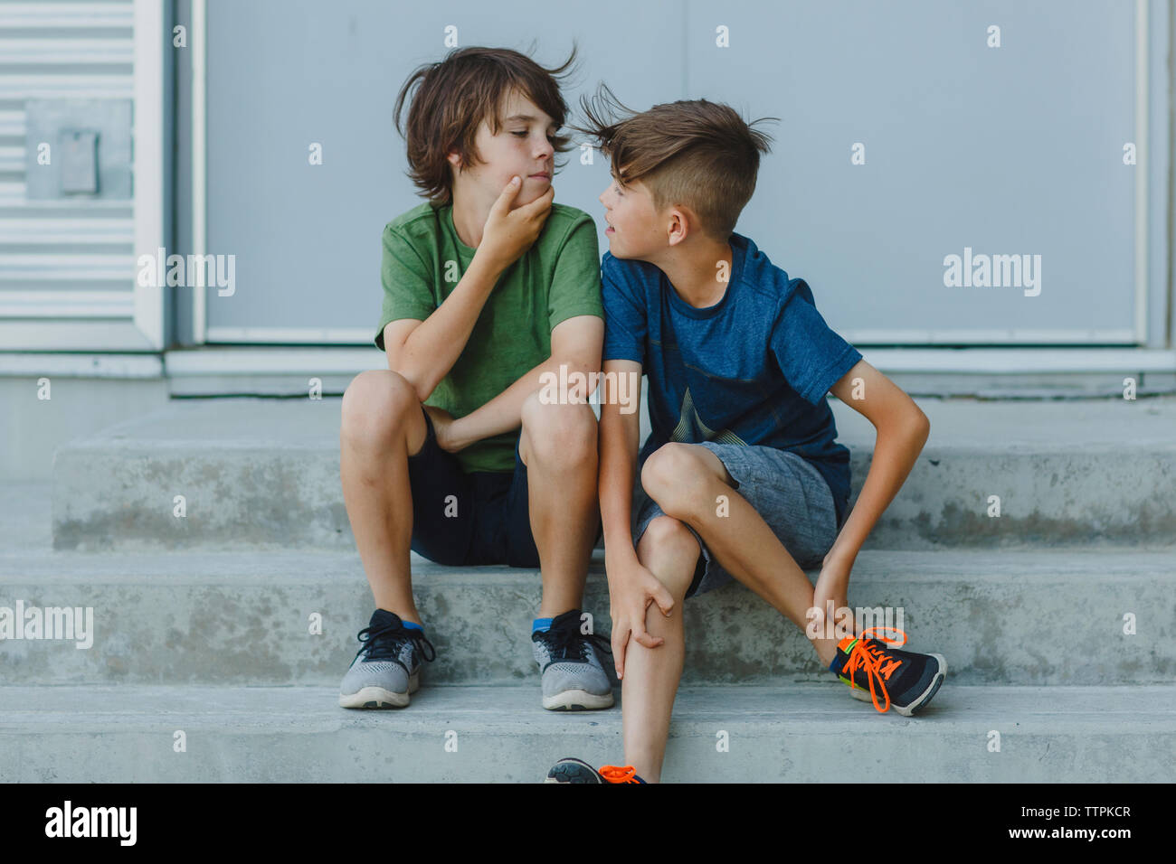 Brothers looking each other face to face outdoors Stock Photo
