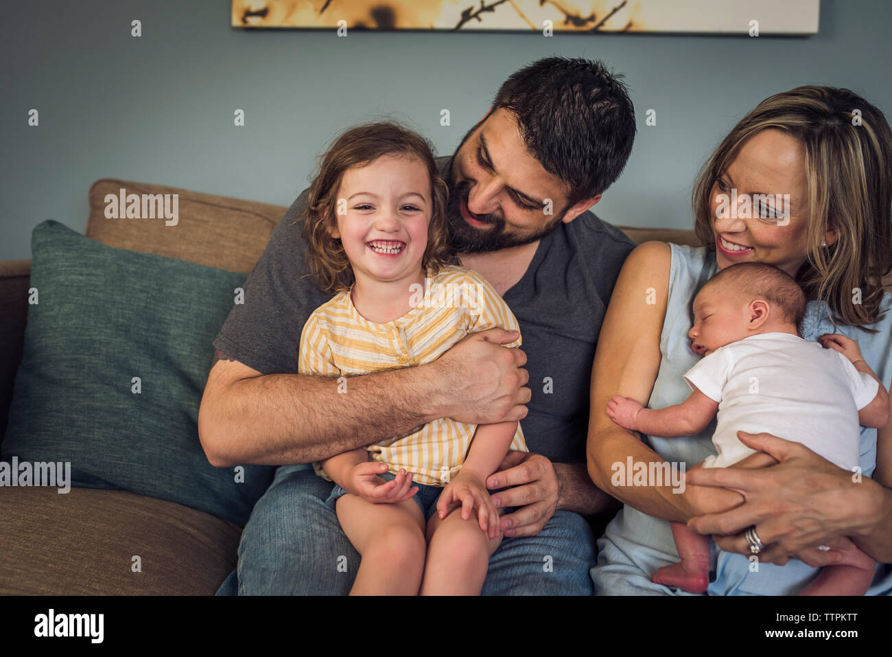 Happy family sitting on sofa at home Stock Photo