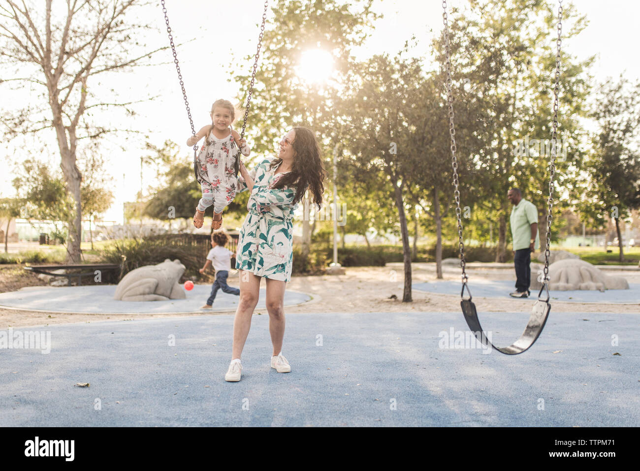 Parents playing with children at playground Stock Photo