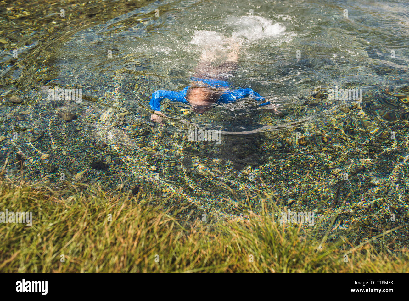 High angle view of carefree boy swimming in lake Stock Photo