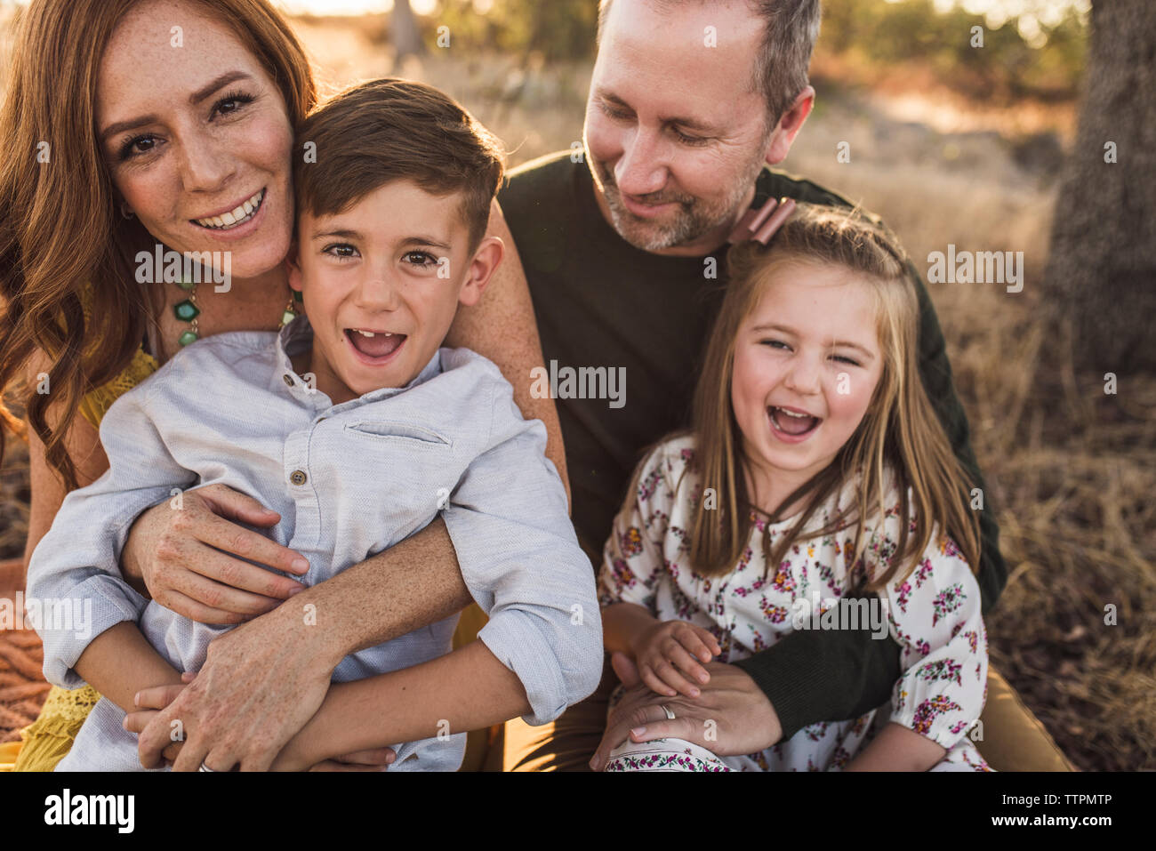 Close up of family laughing while embracing in California field Stock Photo