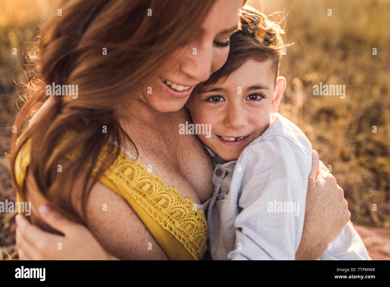 Close up of young boy embraced by smiling mother in California field Stock Photo