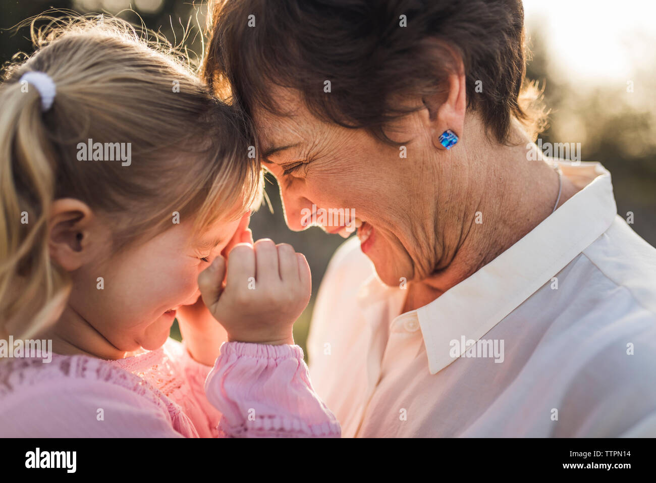 Close up of grandmother and granddaughter looking at each other and la Stock Photo