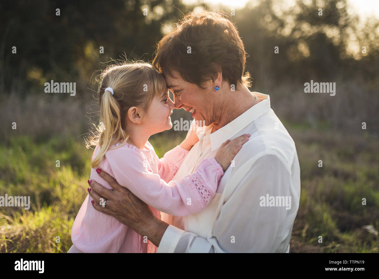 Portrait of grandmother and granddaughter embracing and smiling Stock Photo