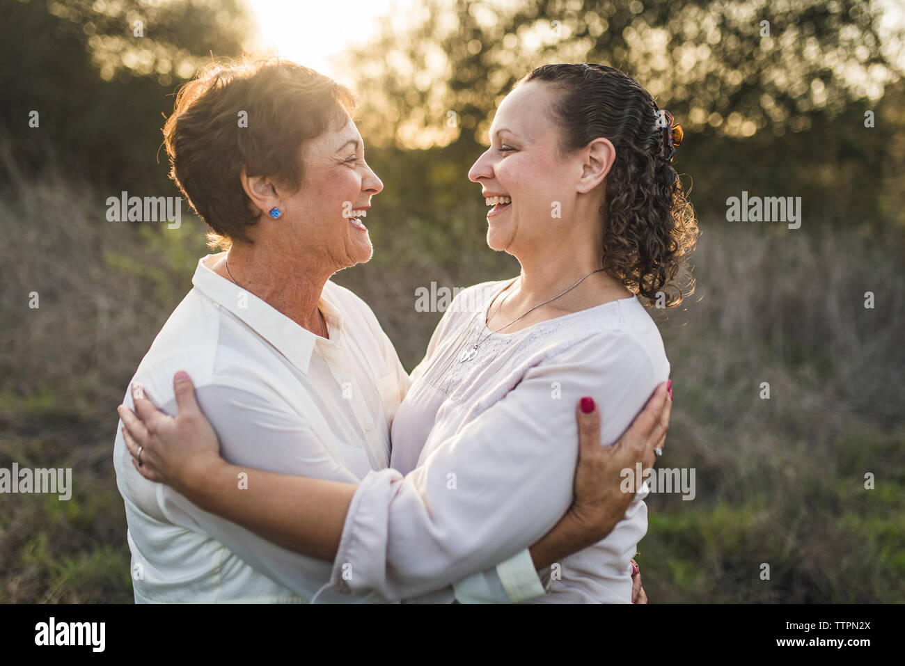 Close up portrait of adult mother and daughter embracing and laughing Stock Photo