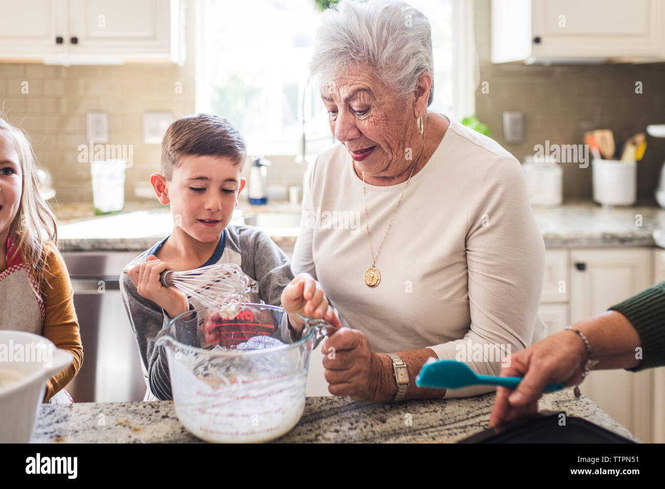 Multigenerational family cooking pancakes for breakfast Stock Photo