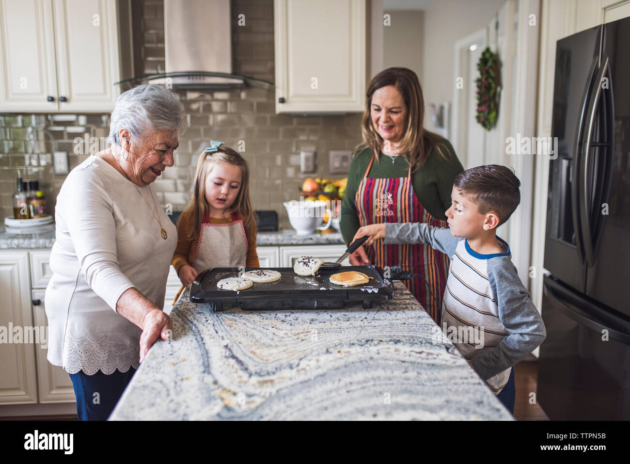 Multigenerational family making breakfast in the kitchen Stock Photo
