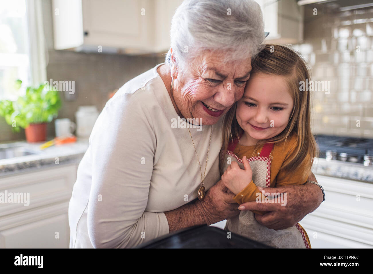 Close up of great grandmother hugging great granddaughter Stock Photo