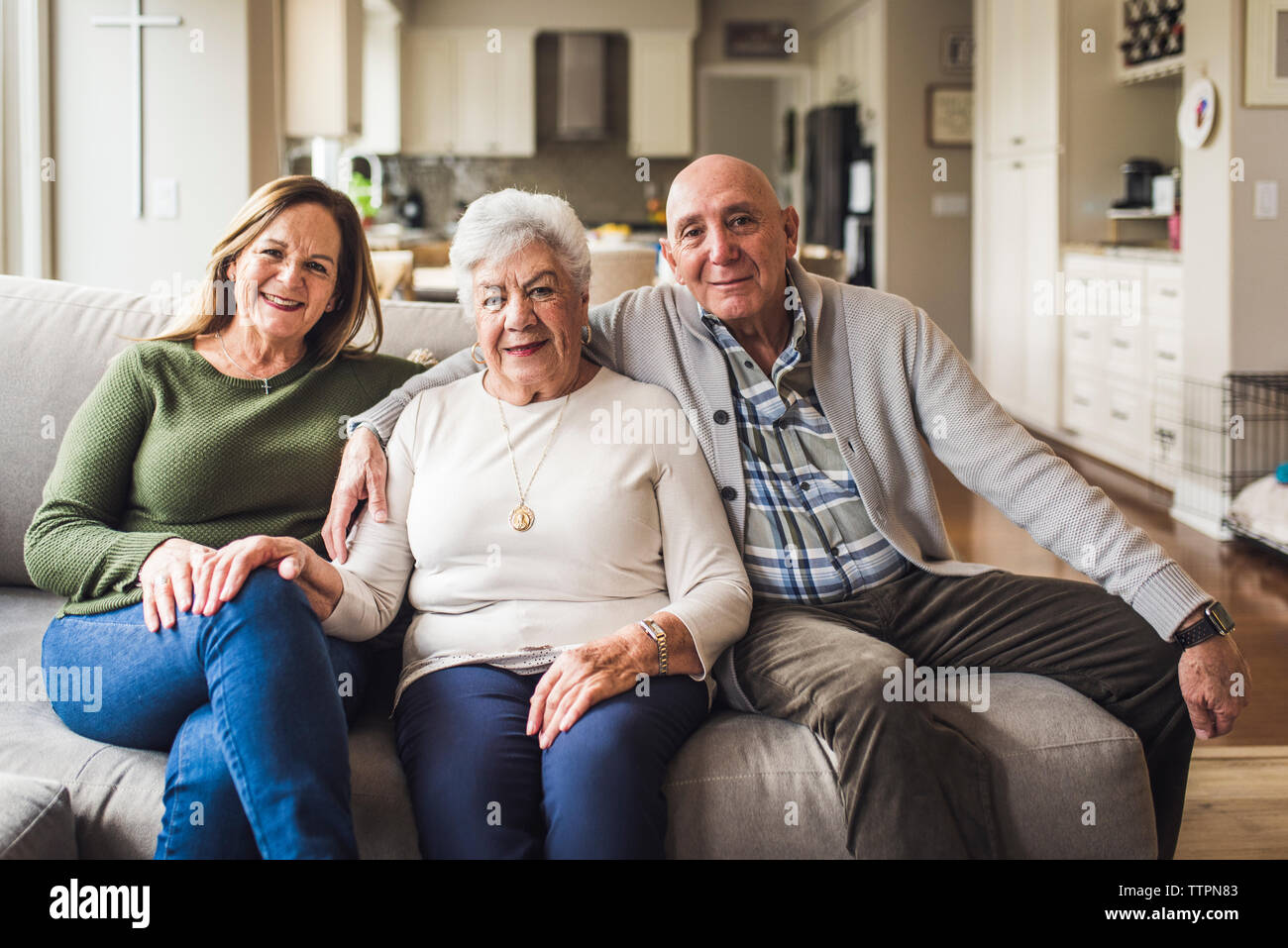 Portrait of multigenerational family sitting on living room couch Stock Photo