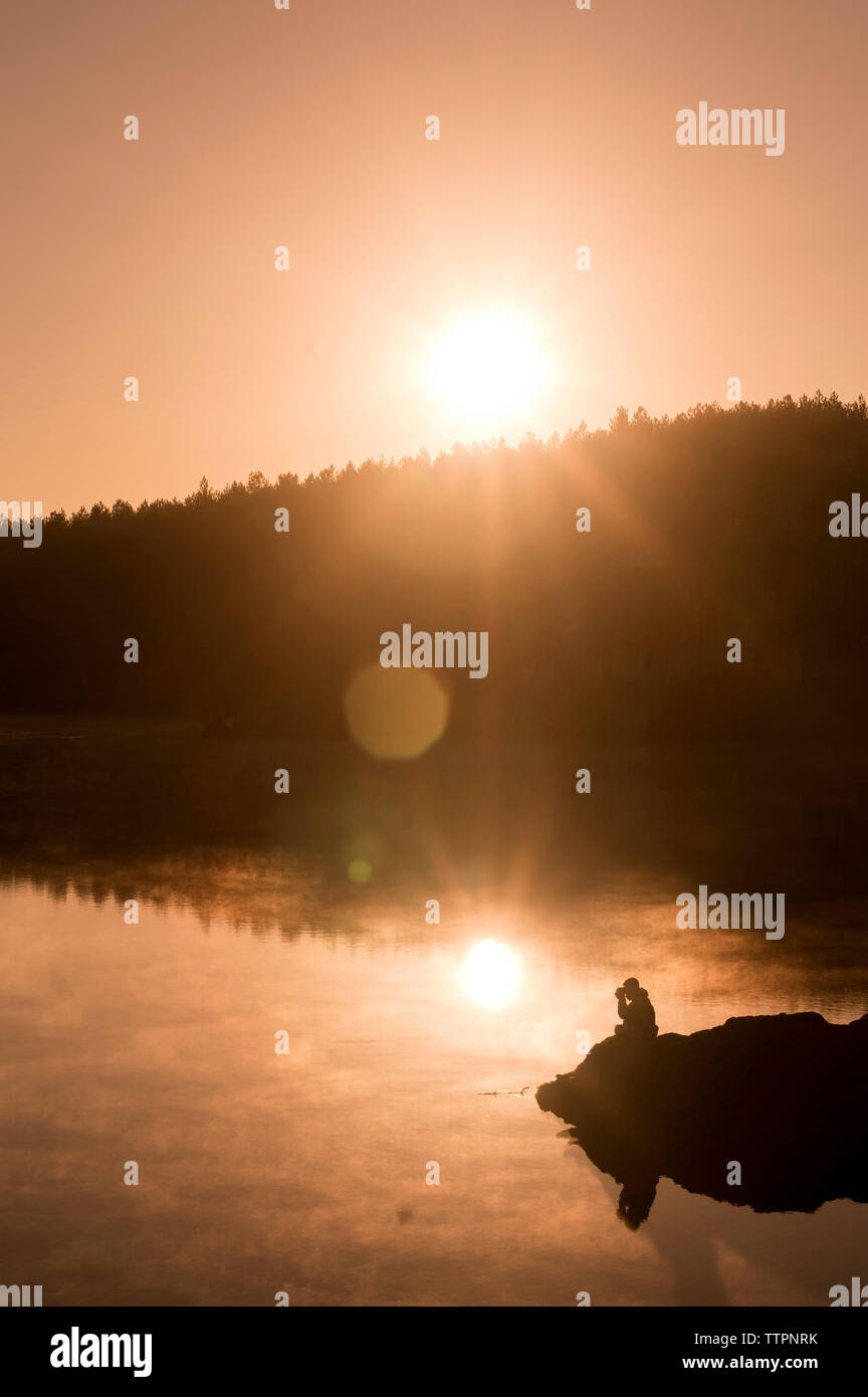 Silhouette man sitting on lake hi-res stock photography and images - Alamy