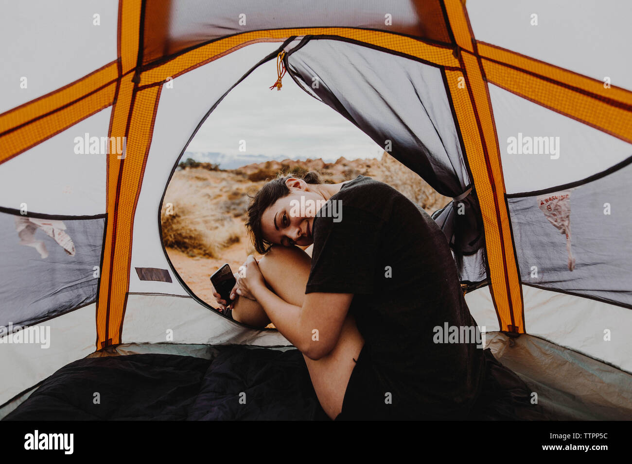 Portrait of woman sitting in tent Stock Photo