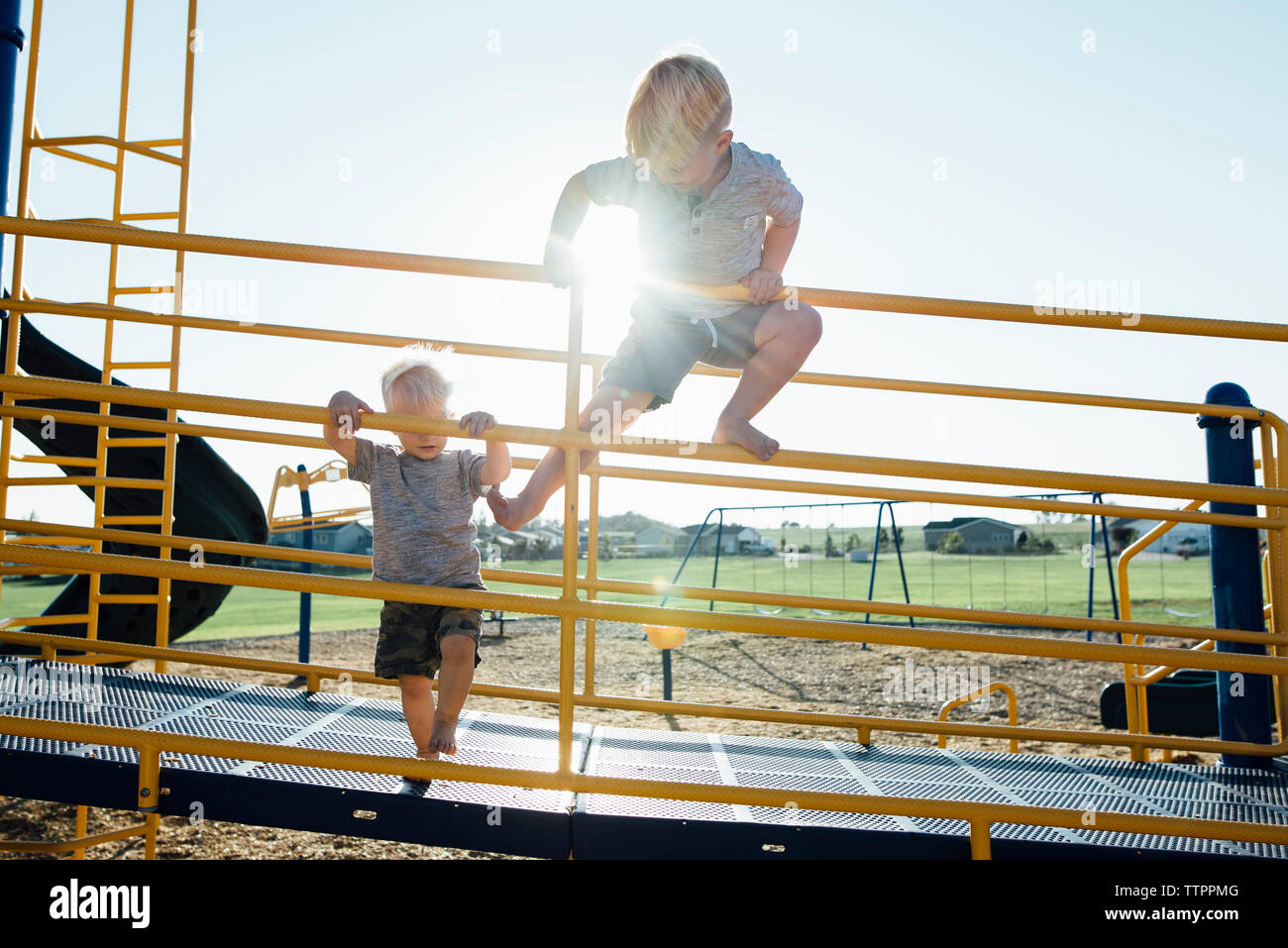 Boys playing on jungle gym at park Stock Photo