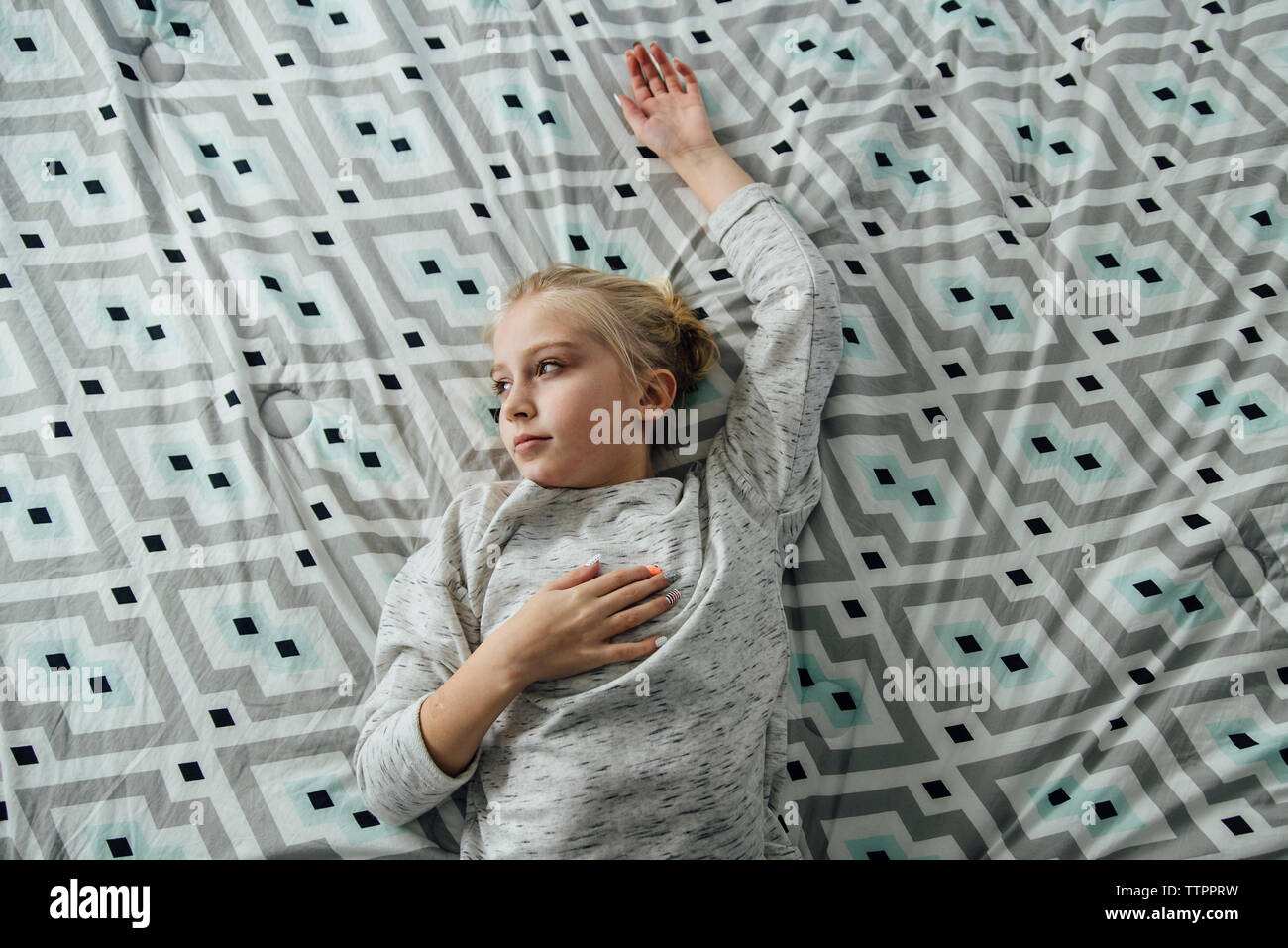 High angle view of thoughtful girl lying on bed Stock Photo