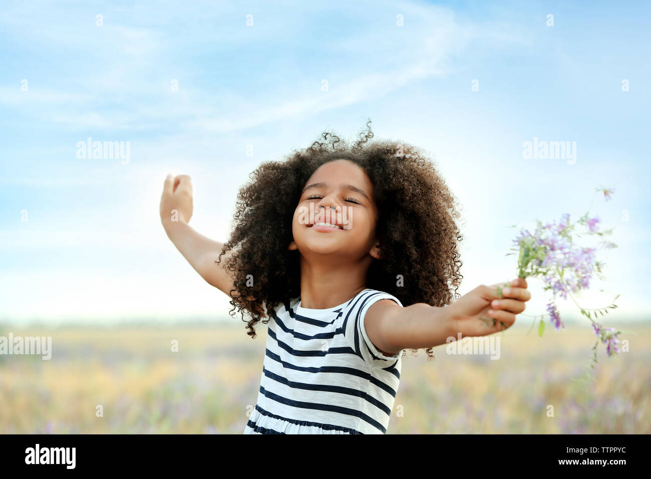 Happy little African American girl in the field Stock Photo - Alamy
