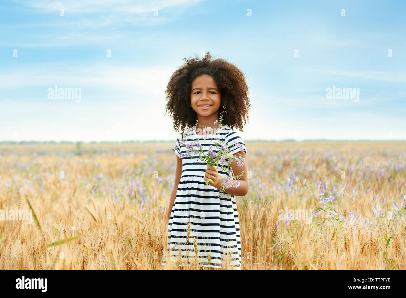 Happy little African American girl in the field Stock Photo - Alamy