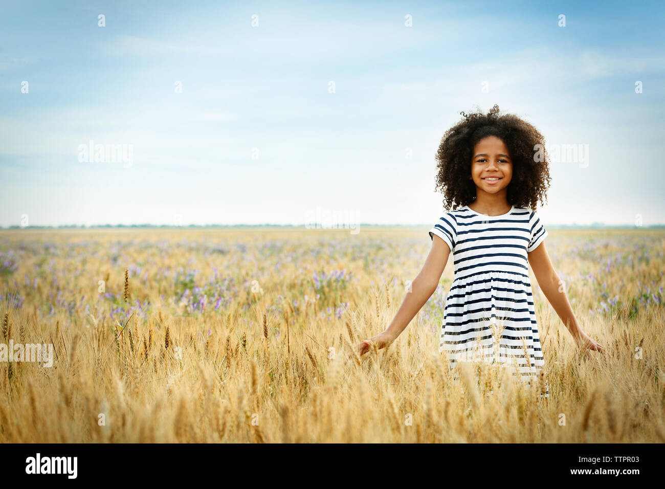 Happy little African American girl in the field Stock Photo - Alamy