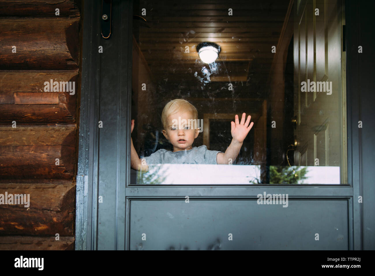 Boy standing by door at home Stock Photo