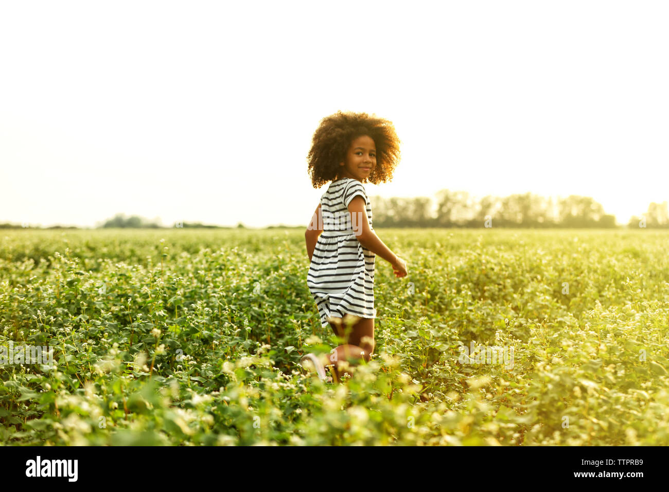 Happy little African American girl in the field Stock Photo - Alamy