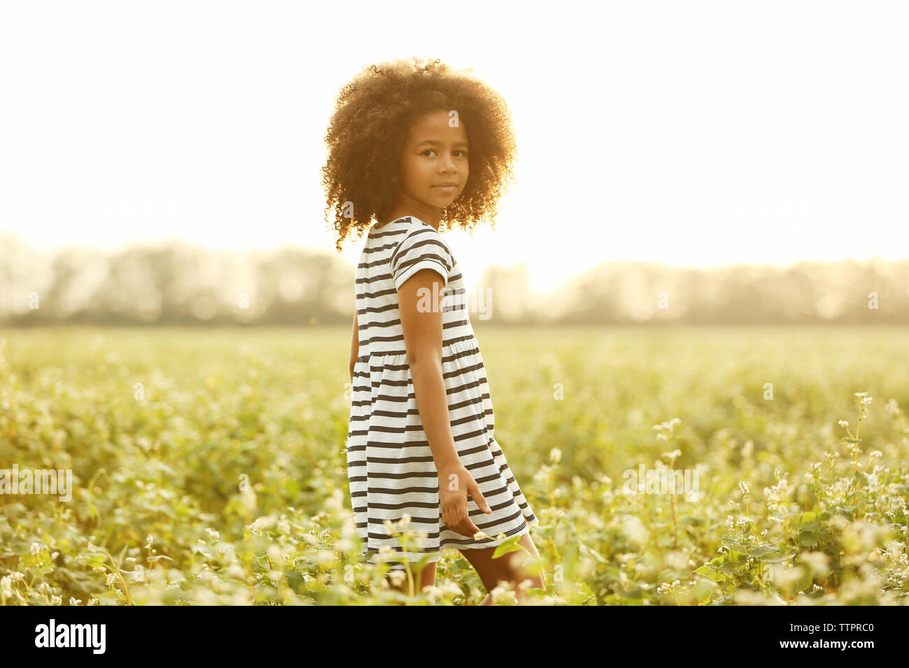 Happy little African American girl in the field Stock Photo - Alamy