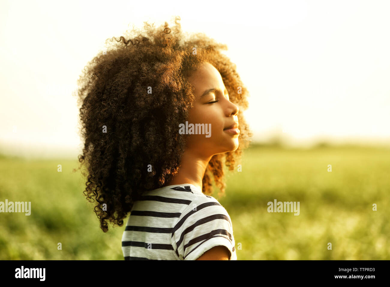 Happy little African American girl in the field Stock Photo - Alamy