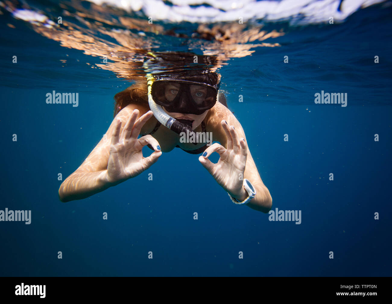 Young woman gesturing while snorkeling undersea Stock Photo