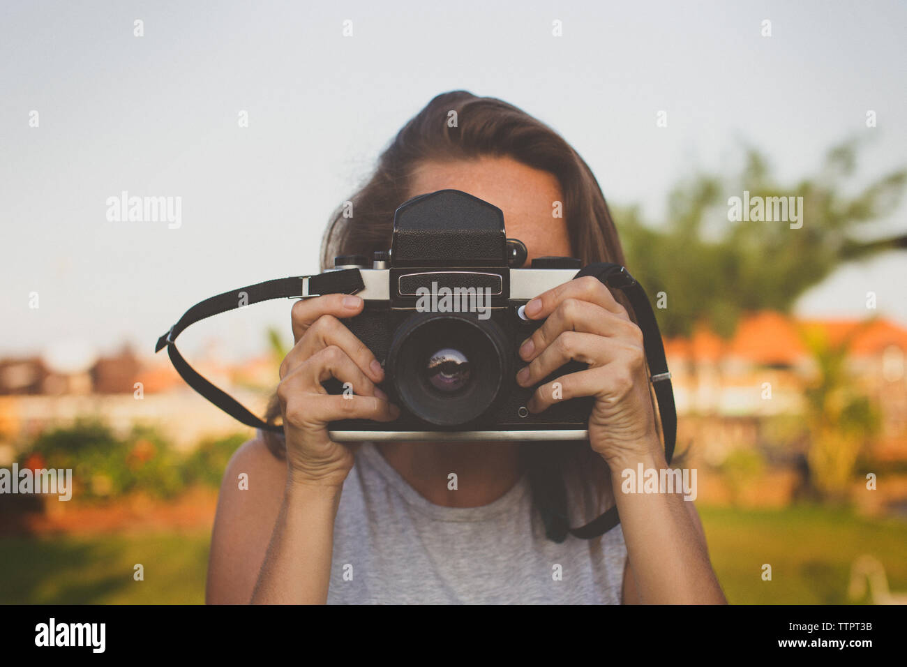 Woman photographing through old-fashioned camera Stock Photo