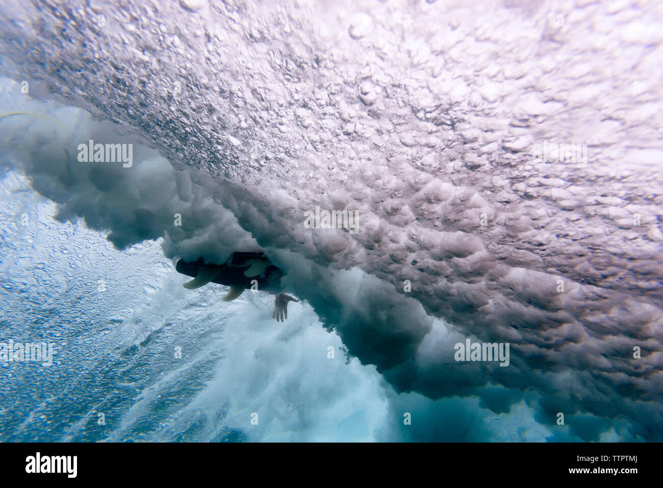 Low angle view of surfboard amidst waves breaking undersea at Maldives Stock Photo