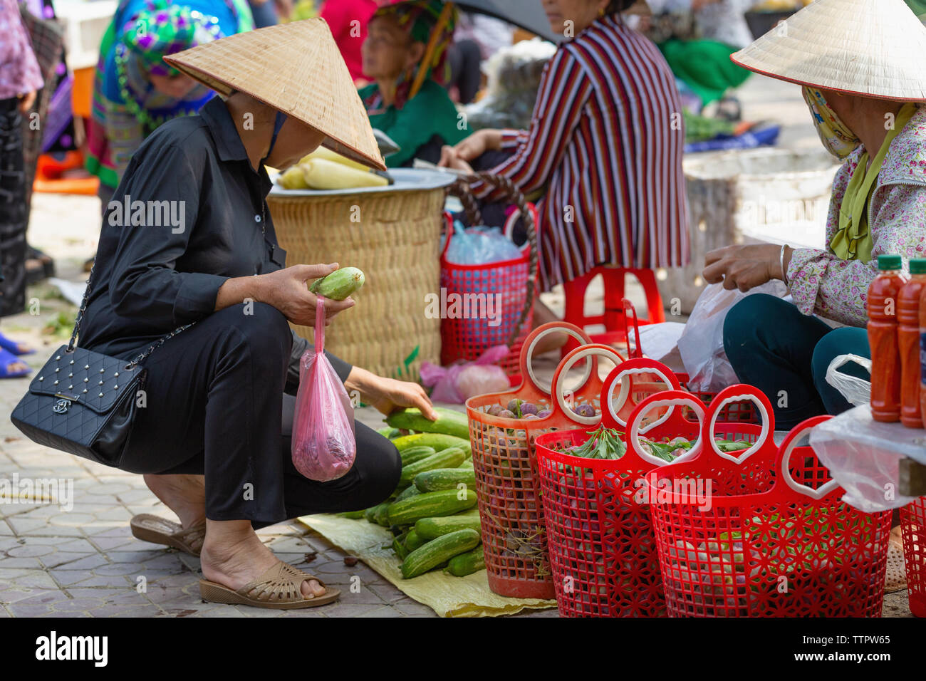 Woman shopper selecting fresh vegetables at local outdoor market, Bac Ha, Lao Cai Province, Vietnam, Asia, Stock Photo