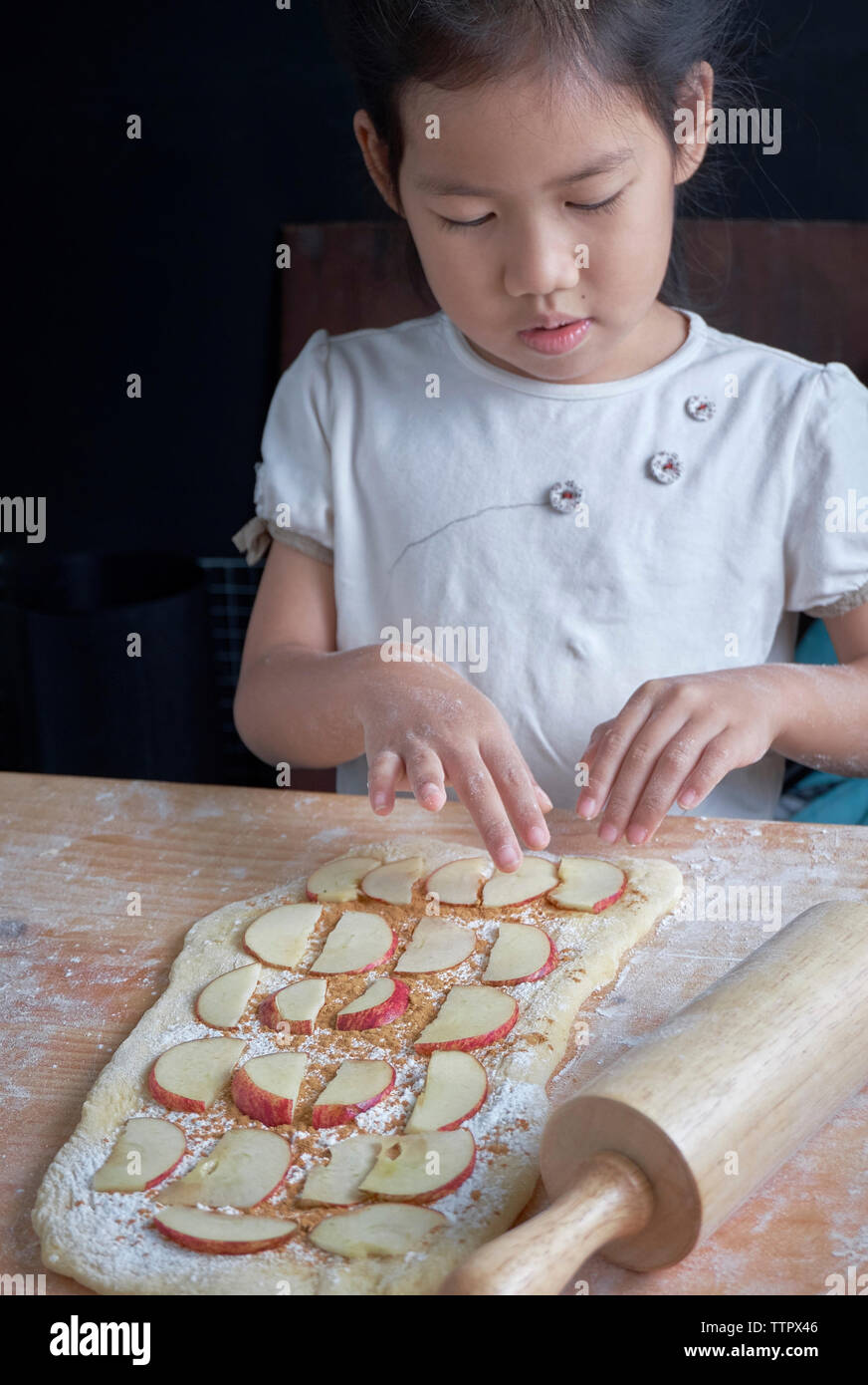 Girl preparing food on wooden table at home Stock Photo